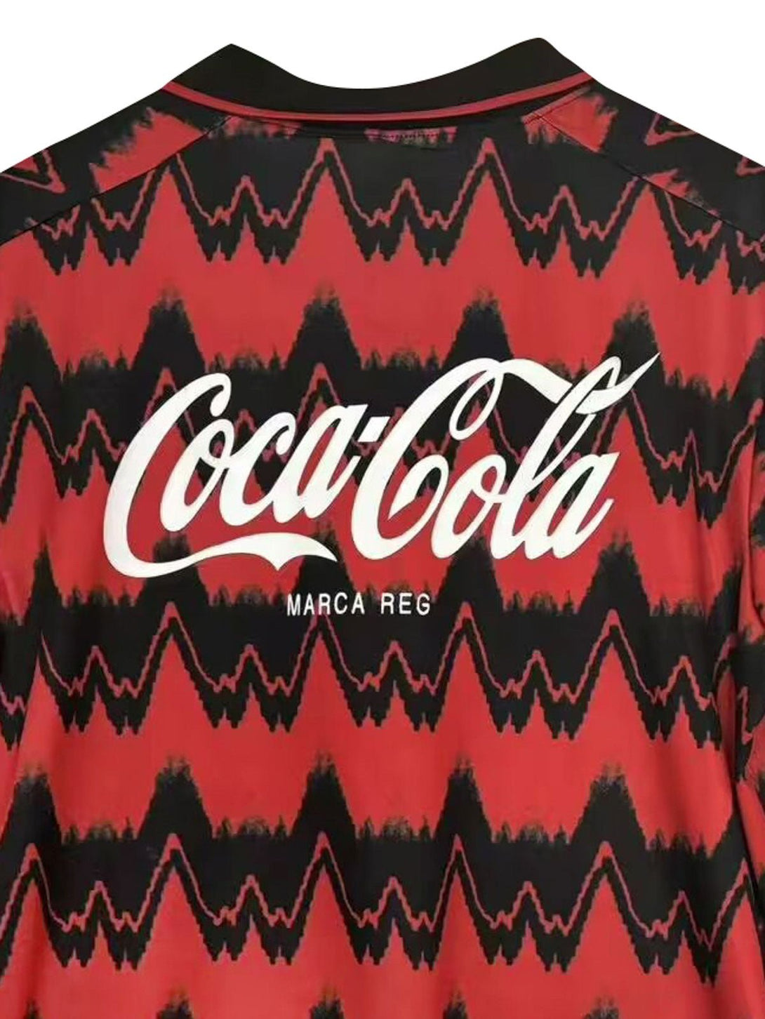 詳細画像: ユニフォームのCoca-Colaスポンサーのロゴとクラブエンブレムのディテール展示。