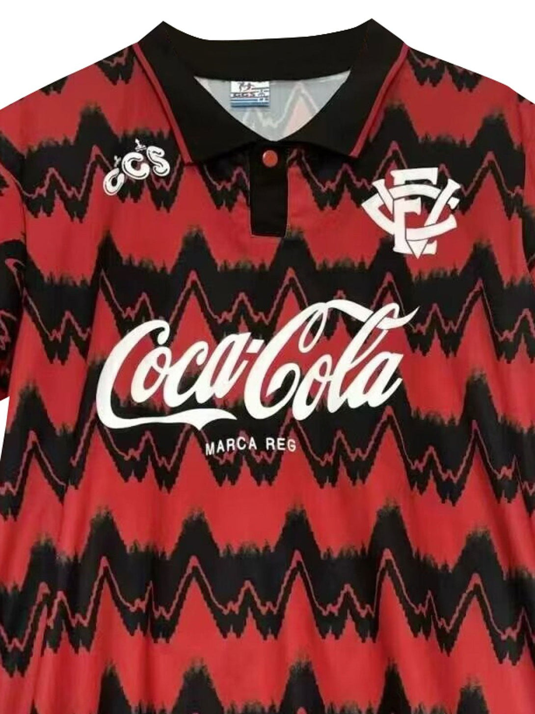 詳細画像: ユニフォームのCoca-Colaスポンサーのロゴとクラブエンブレムのディテール展示。