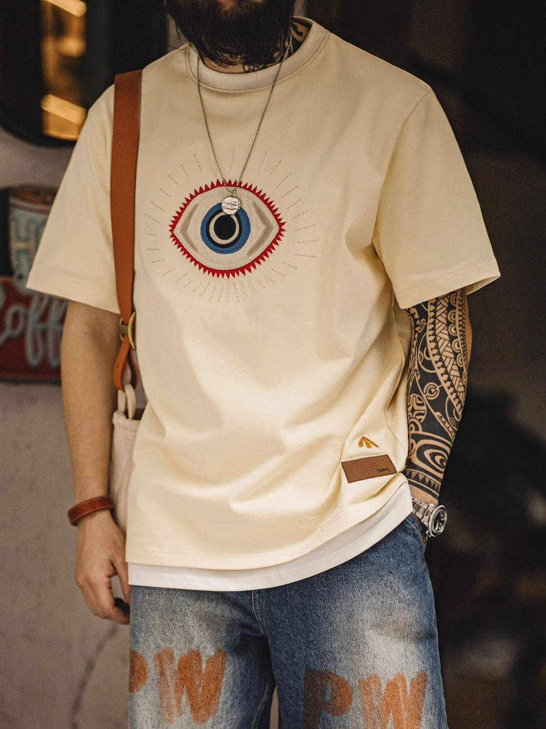 モデルが「守護の眼」ショートスリーブTシャツを着用し、そのスタイルとフィット感を披露する全身像。