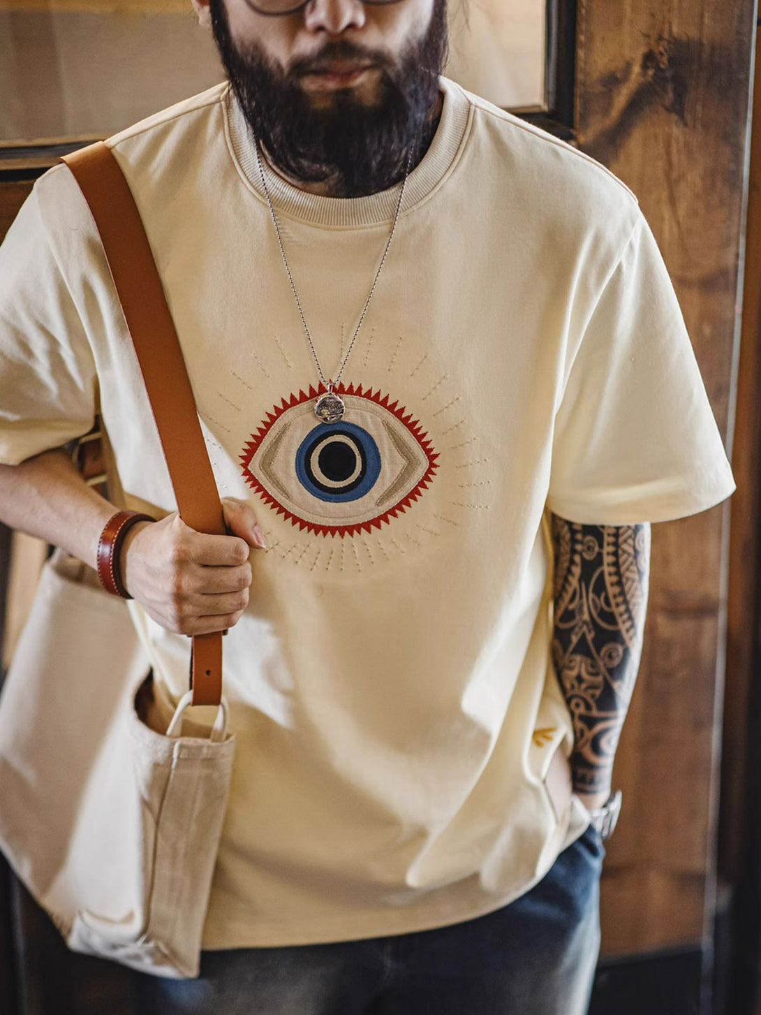 モデルが「守護の眼」ショートスリーブTシャツを着用し、そのスタイルとフィット感を披露する全身像。