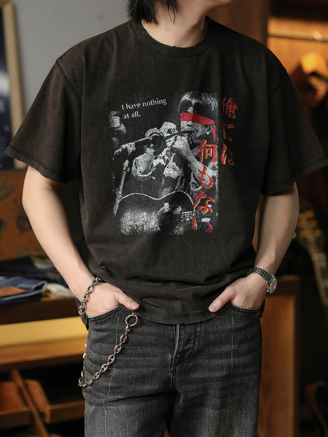 90年代の崔健BANDTEEを模したデザインのTシャツを着用するモデル。ヴィンテージ感溢れるスプラッター柄とサビ效果で、荒廃した雰囲気を演出。