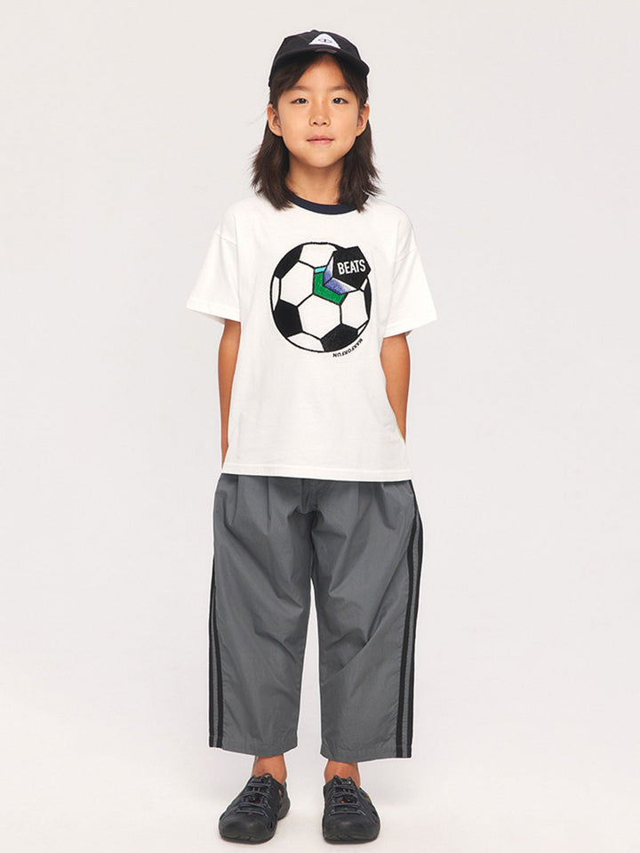 子供がサッカーテーマTシャツを着用して活動している様子