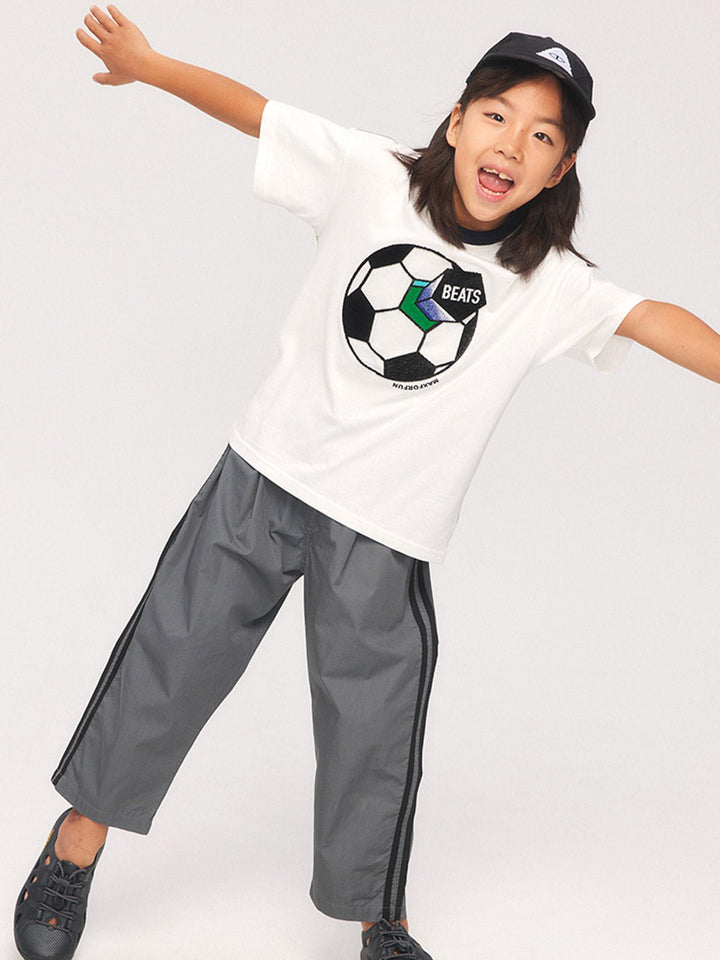 子供がサッカーテーマTシャツを着用して活動している様子